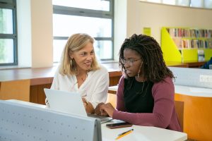 Female Teacher and Student in Library